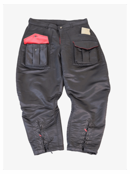 Black and red satin utility pants with oversized cargo pockets, red flap detail, lace-up ankles, and a glossy finish – designed by RCSLA