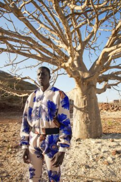 Model is wearing an oversized bomber with matching joggers from the RCSLA Collection. Shot in front of a Baobab Tree